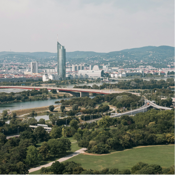 city-skyline-with-river-bridge-and-green-parkland-view